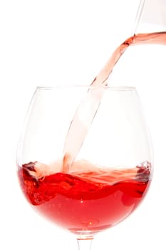 Pouring rose in glass over white background