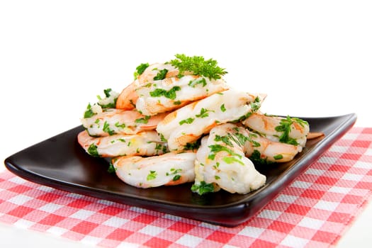 Plate with prawn snacks on checkered napkin over white background