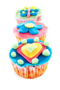 three cupcakes with marzipan decoration over white background