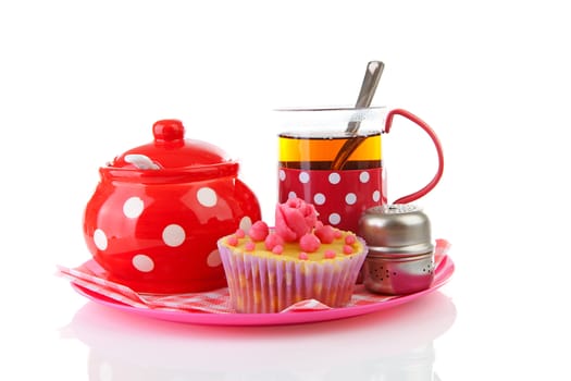 Plate with cup of tea and cupcake over white background