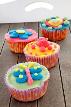 Tray with four delicious decorated colorful cupcakes