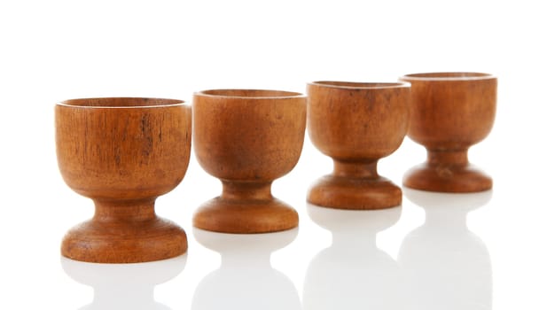 Empty wooden egg holders over white background