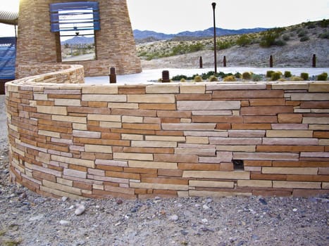 Curved sandstone wall at modern bridge