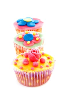 three cupcakes with marzipan decoration over white background