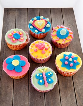 Couple of cupcakes with marzipan decoration on wooden background