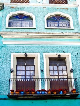 Colorful Mexican building with balcony and flowerpots