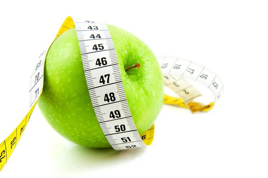 Fresh green apple with measure tape over white background