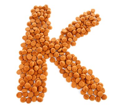 Ginger nuts, pepernoten, in the shape of letter K isolated on white background. Typical Dutch candy for Sinterklaas event in december