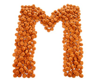 Ginger nuts, pepernoten, in the shape of letter M isolated on white background. Typical Dutch candy for Sinterklaas event in december