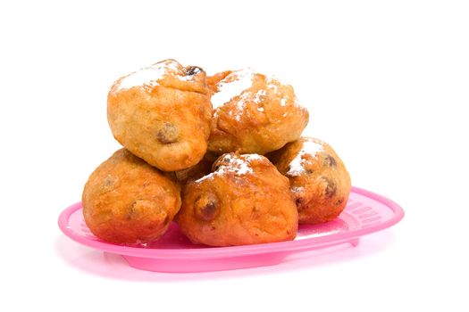 pink plate with Dutch donut also known as oliebollen, traditional New Year's eve food isolated on white background
