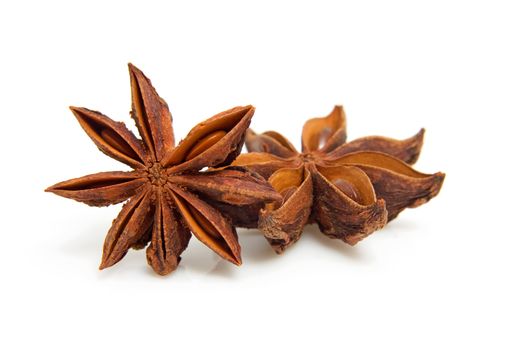two whole star anise in closeup over white background
