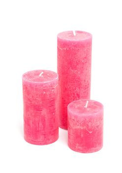 Three pink candles isolated on white background