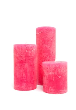 Three pink candles isolated on white background
