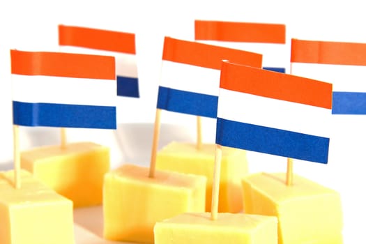 cheese cubes in closeup with Dutch flags for party over white background