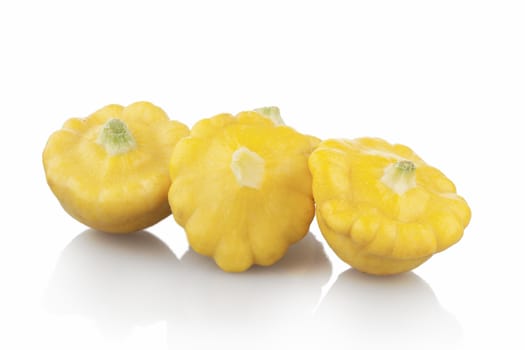 Three pattypan squash on white background with shadows