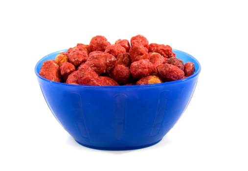 Blue bowl with sugared peanuts over white background