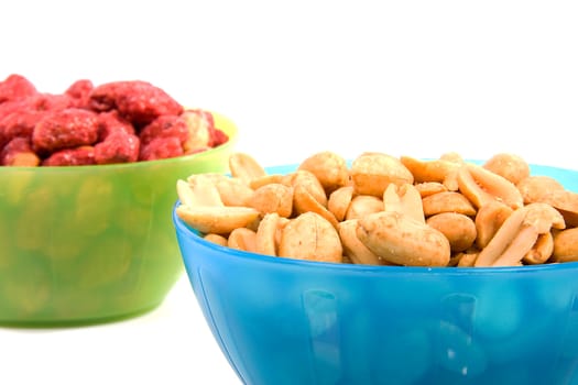 bowls with sugared and salted peanuts over white background