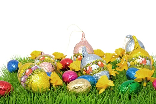 chocolate easter eggs on graas over white background