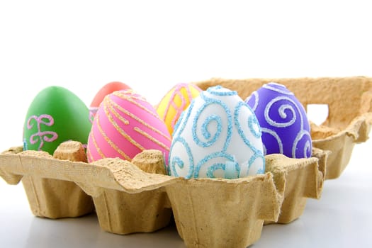 Six colorful easter eggs in box over white background