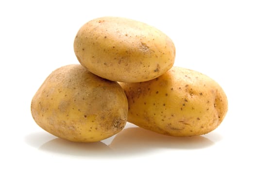 Stack of three unpeeled potatoes isolated on white background