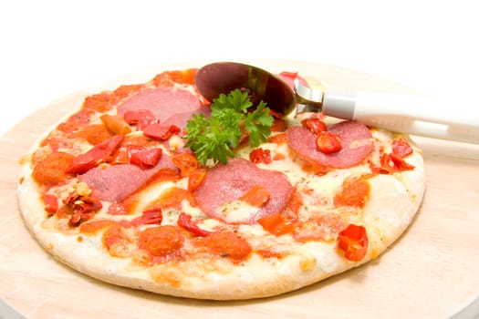 Tasty pizza with salami on wooden board over white background