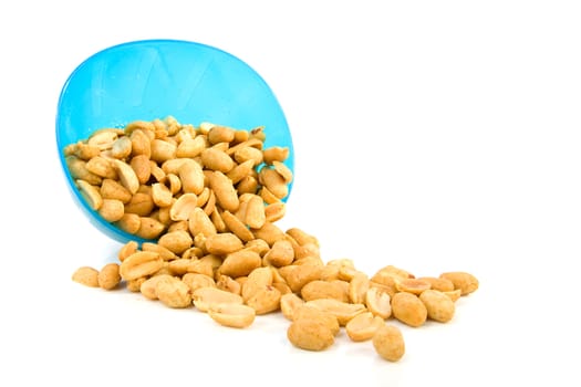 Salted peanuts falling out of blue bowl over white background