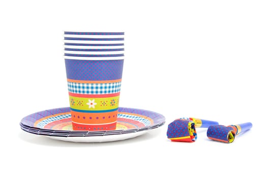 stack of birthday plates and cups with noisemakers isolated on white background
