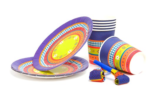 stack of birthday plates and cups with noisemakers isolated on white background