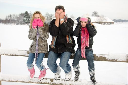 three people in snow showing speak, see and hear no evil