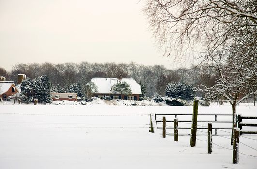 Landscape with Dutch farm in the snow it's winter time