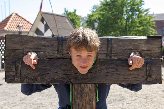 a boy trapped in a medieval torture device