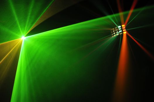 Colour lasers in smoke on a black background.