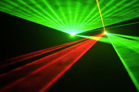 Colour lasers in smoke on a black background.