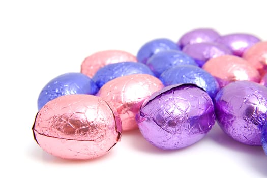 colorful chocolate easter eggs in closeup over white background