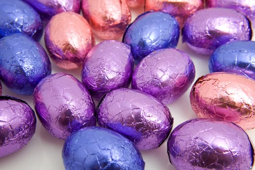 colorful chocolate easter eggs in closeup over white background