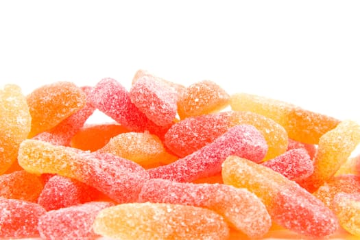 Pile of colorful sugar candy in closeup over white background