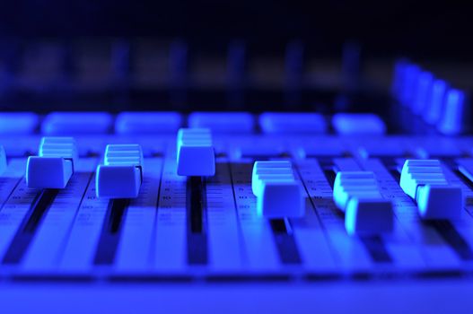 Mixing console illuminated by blue light