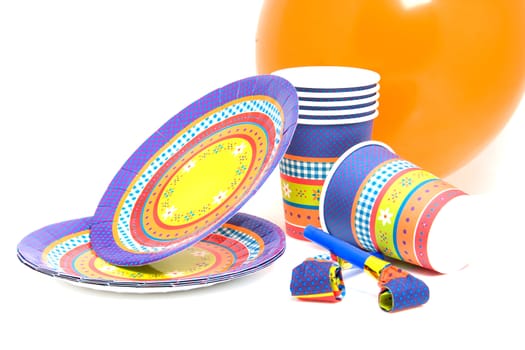 stack of birthday plates and cups with noisemakers isolated on white background