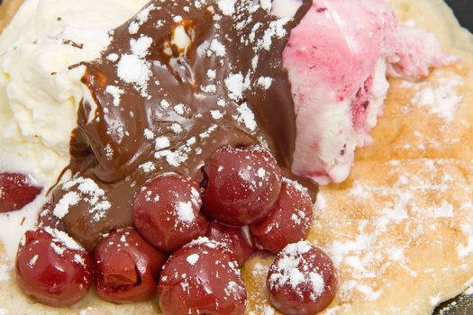 delicious dessert with waffle, ice cream and cherries in closeup