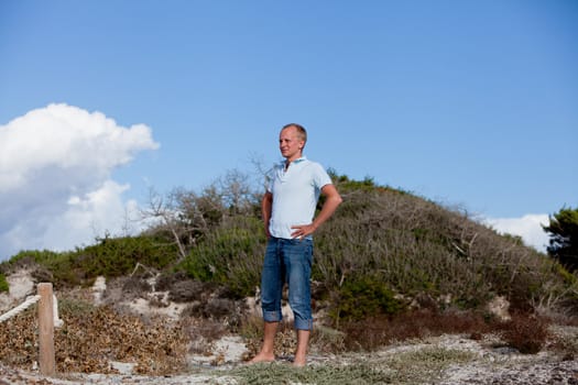 young man is relaxing outdoor in dune in summer vacation