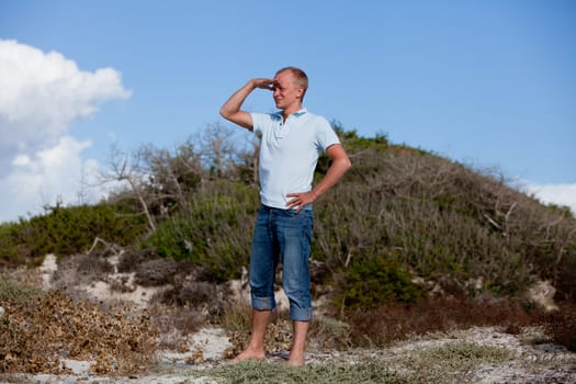 young man is relaxing outdoor in dune in summer vacation