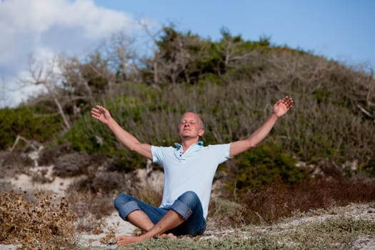 young man is relaxing outdoor in dune in summer vacation