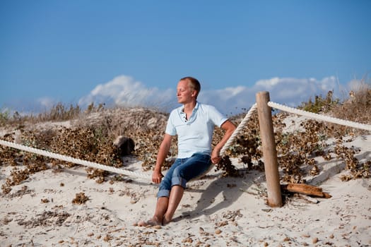 young man is relaxing outdoor in dune in summer vacation