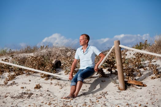 young man is relaxing outdoor in dune in summer vacation