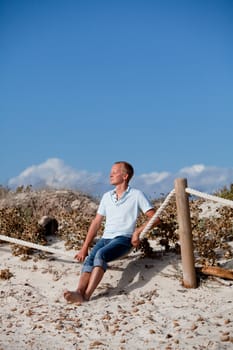 young man is relaxing outdoor in dune in summer vacation