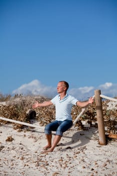 young man is relaxing outdoor in dune in summer vacation
