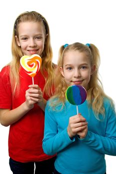 Two young blonde girls with lollipop over white background