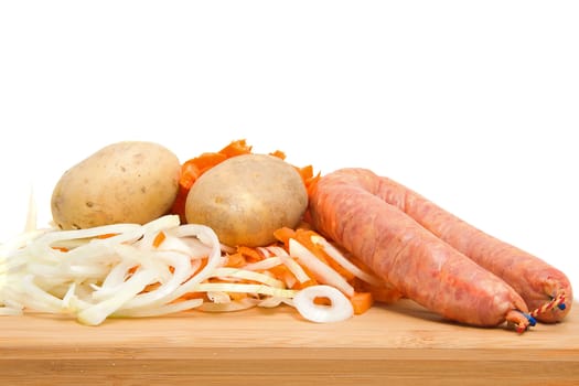 Ingredients for Dutch hutspot stew on wooden cutting board over white background