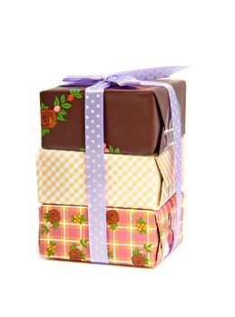 Pile of birthday presents with purple bow isolated on white background