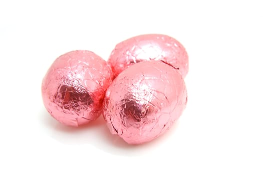 Three pink chocolate easter eggs over white background